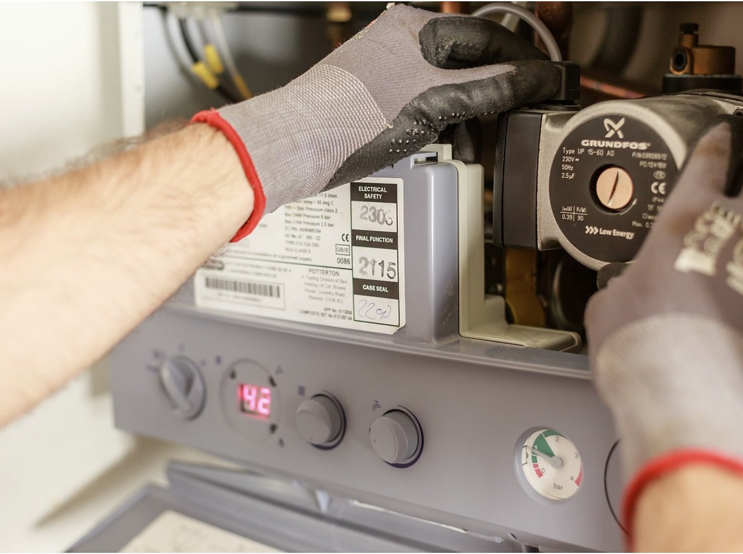 Engineer servicing a gas boiler control panel